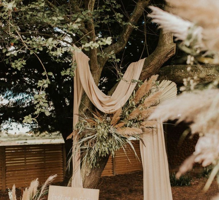 Boho decor and wooden seating chart for August 2020 wedding