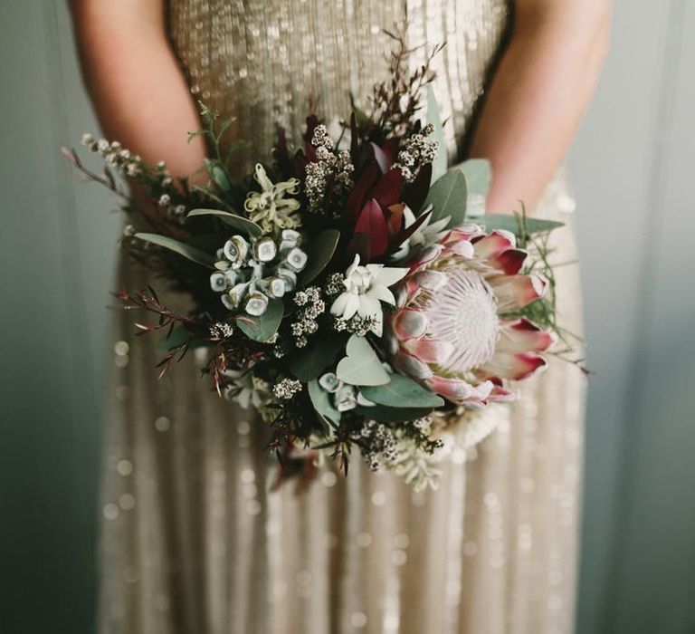 Bride in Gold Wedding Dress Holding King Protea Wedding Bouquet