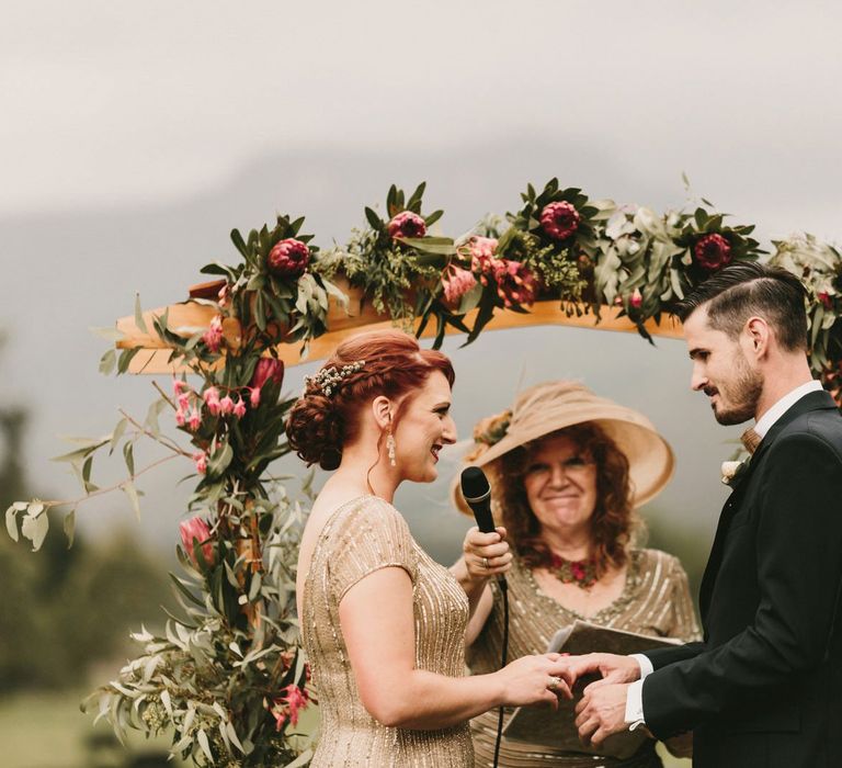 King Protea Floral Altar with Bride in Sequin Gold Wedding Dress and Groom  in Dark Suit