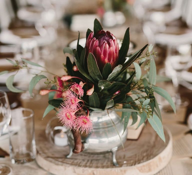 Pink Flowers in Silver Vessel on Tree Slice as Table Centrepiece