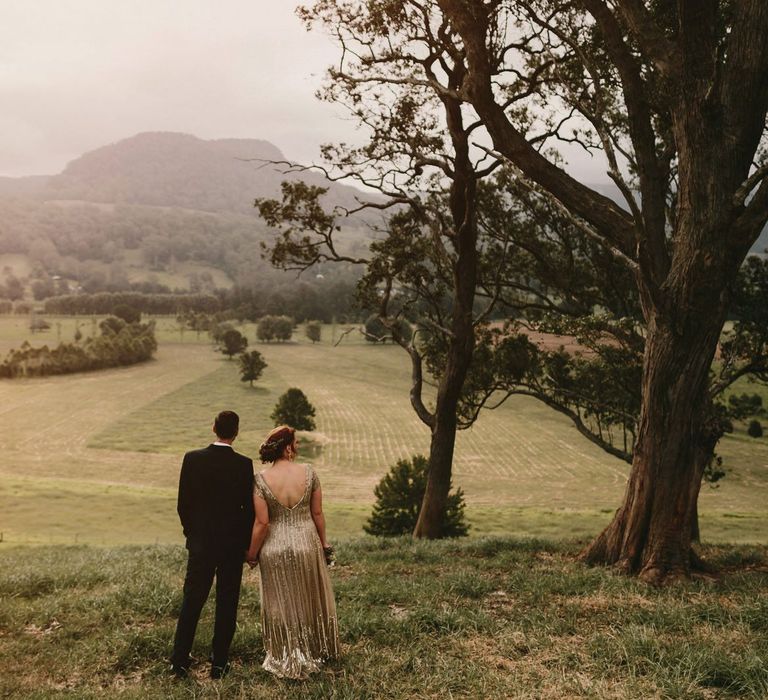 Bride in Sequin Gold Wedding Dress an Groom in Dark Suit with Wood Bow Tie