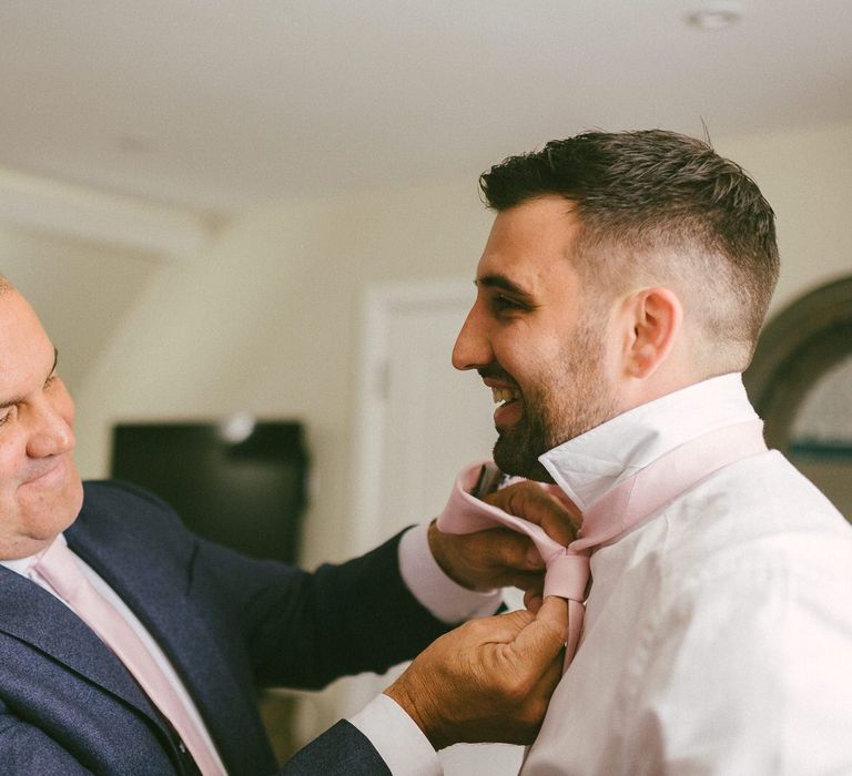 Groom having his Tie Fixed