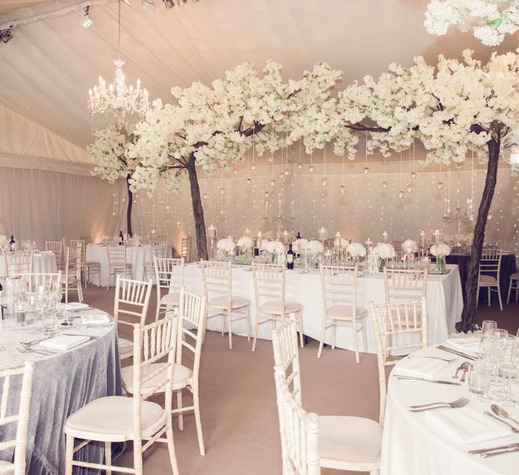 Marquee Reception at Iscoyd Park with Blossom Trees Over Top Table and Fairy Light Backdrop