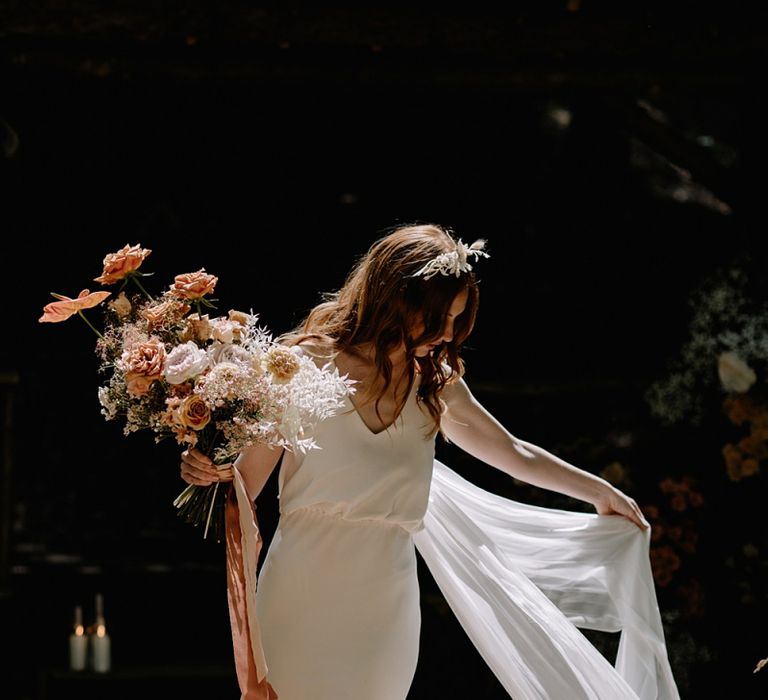 Bride in Fitted Wedding Dress and Wedding Veil Holding an Orange Flower Bouquet