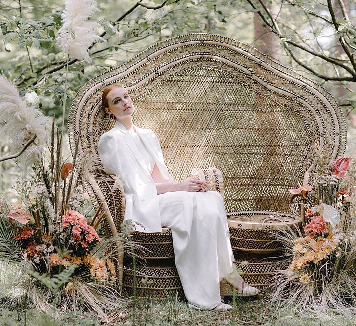 Bride in Blazer Sitting on a Double Peacock Chair in the Woods