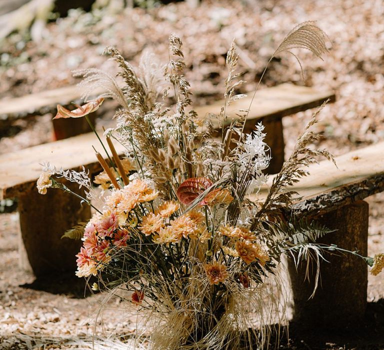 Wooden Benches and Floral Arrangements of Dried Grasses &amp; Orange Flowers