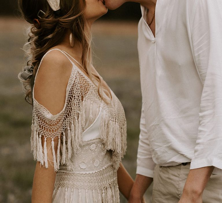 Boho Couple Kissing with Bride in Cold Shoulder Lace Dress and Groom in Fedora Hat