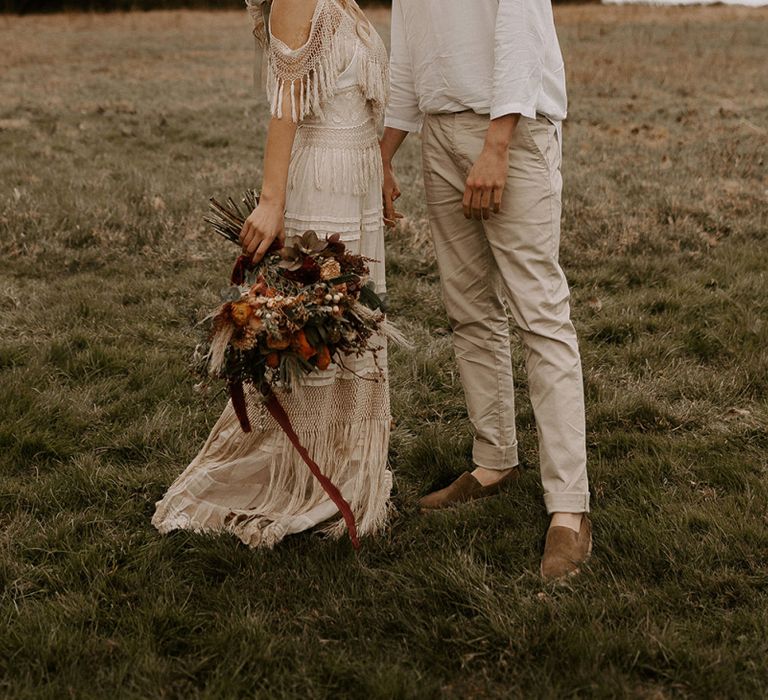 Boho Bride and Groom Kissing in a Field