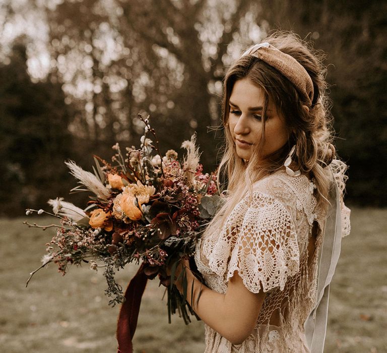 Boho Bride in Lace Wedding Dress Holding a Boho Wedding Bouquet