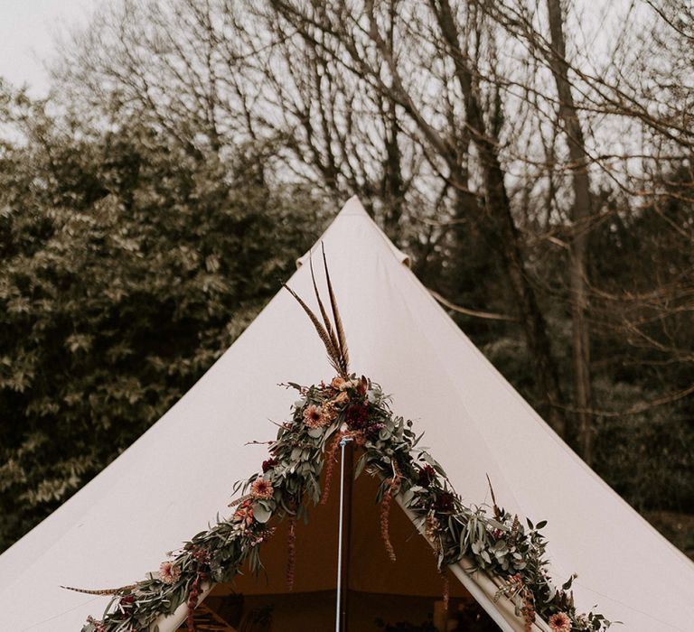 Bell Tent with Flower Covered Entrance and Cosy Seating Area Inside