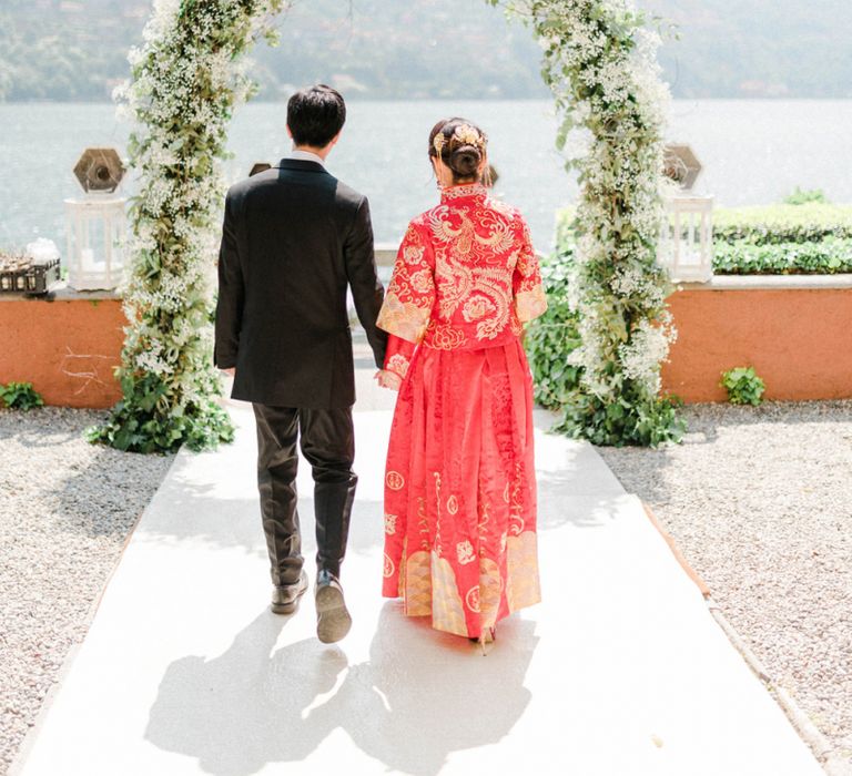 Chinese Tea Ceremony  Wedding White and Green Floral Arch with Bride in Traditional Chinese Red Dress and Groom in Black Suit