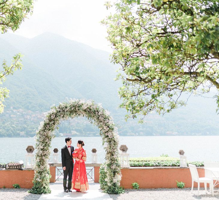 Chinese Tea Ceremony Wedding White and Green Floral Arch with Asian Bride in Traditional Chinese Red Dress and Groom in Black Suit