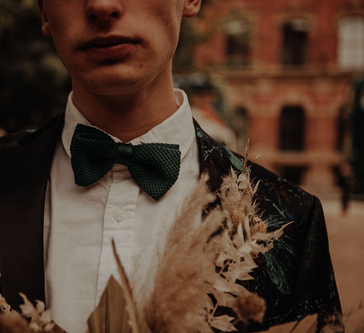 Groom in green bow tie with patterned suit