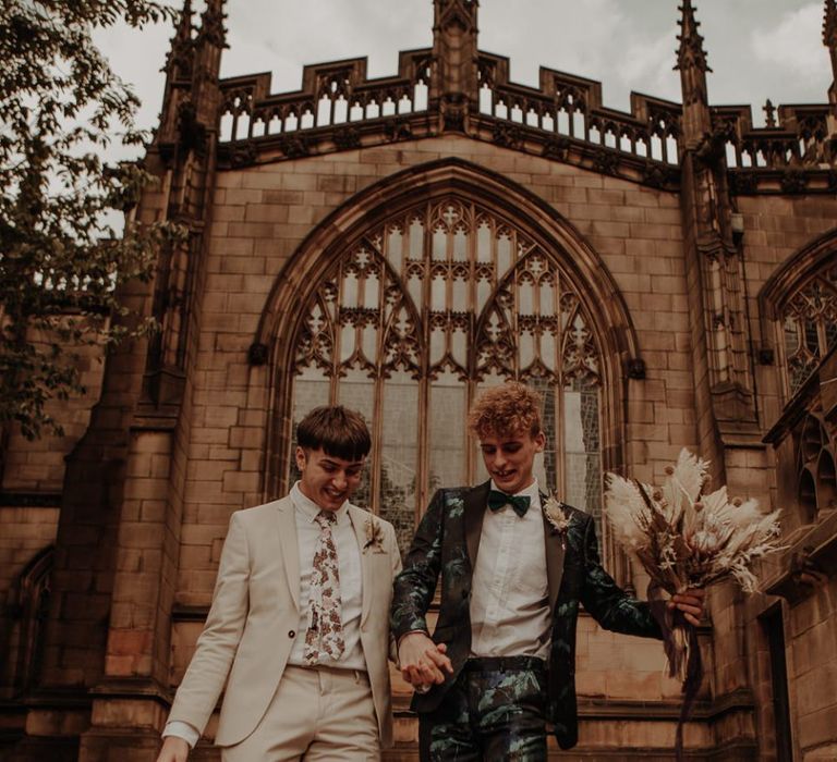 Same sex couple walking down the some steps just married