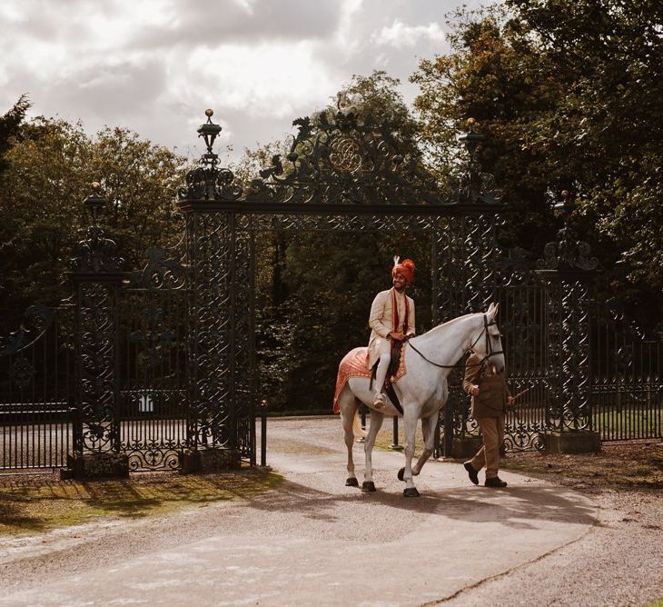 Grooms Hindu wedding ceremony entry on a white horse