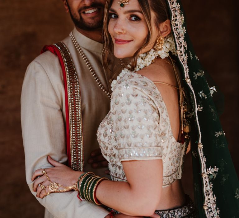 Groom in red and gold Indian wedding suit