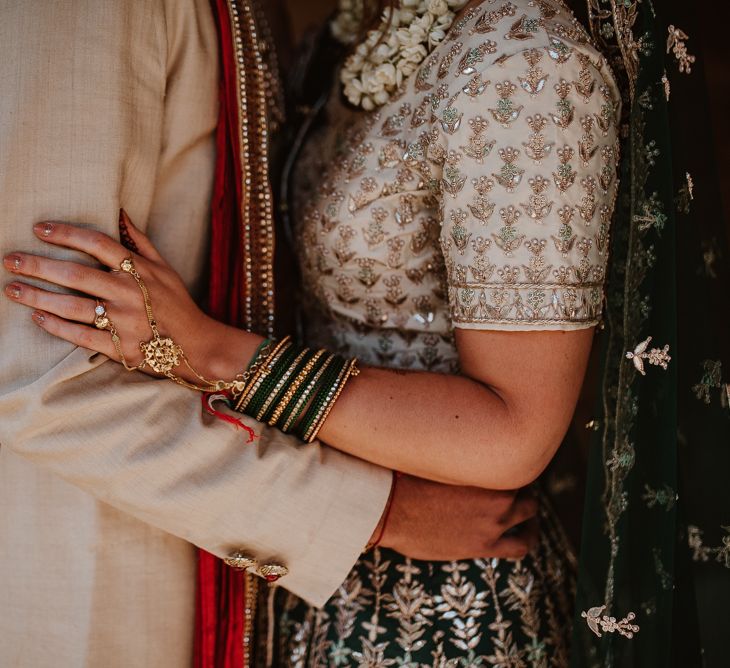 Bride with Indian bangles and gold hand chain.