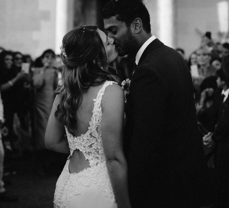 Bride and groom kissing at the end of the confetti moment