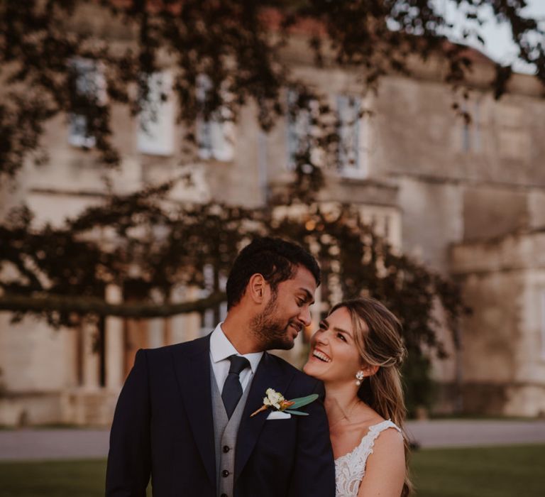 Groom in three-piece suit and bride in Maggie Sottero wedding dress