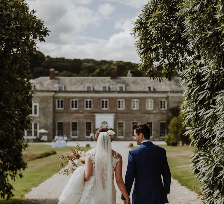 Bride in Lace Back Pronovias Wedding Dress | Groom in Hawes and Curtis Navy Suit &amp; Bow Tie | Outdoor Cornish Wedding at Boconnoc Estate | Nick Walker Photography