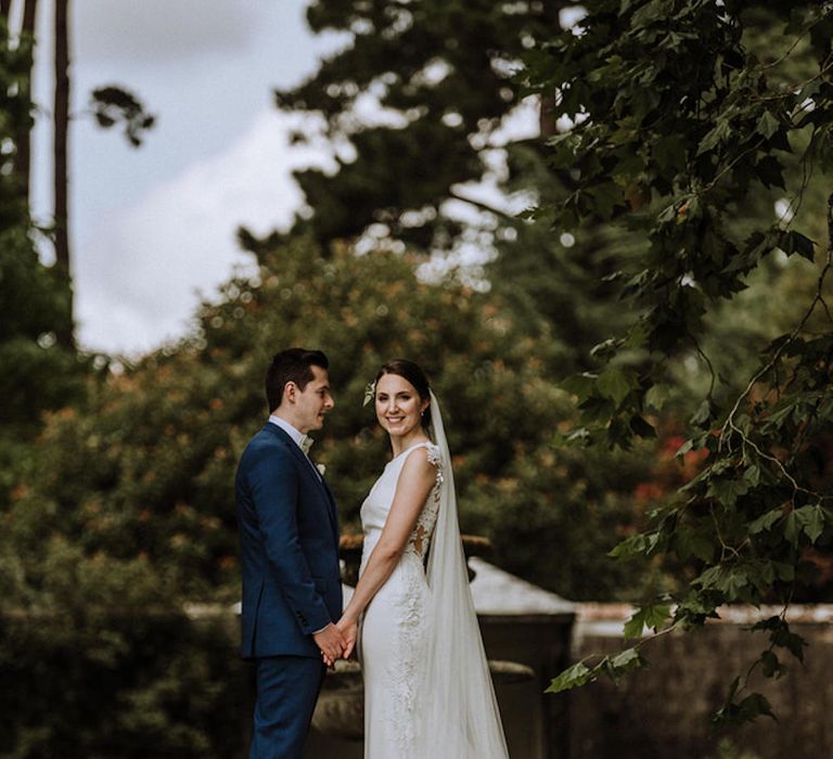 Bride in Lace Back Pronovias Wedding Dress | Groom in Hawes and Curtis Navy Suit &amp; Bow Tie | Outdoor Cornish Wedding at Boconnoc Estate | Nick Walker Photography