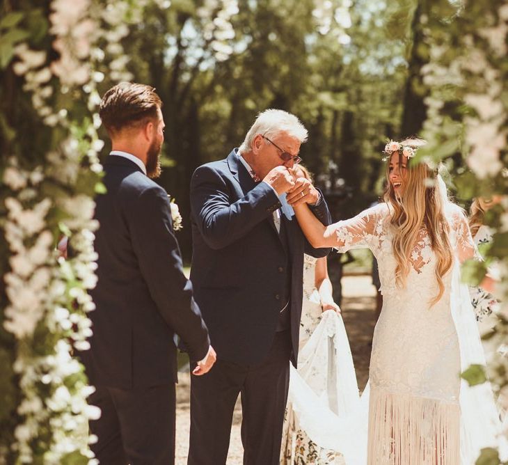 Bride In Handmade Wedding Dress and Groom Under Flower Arch Altar