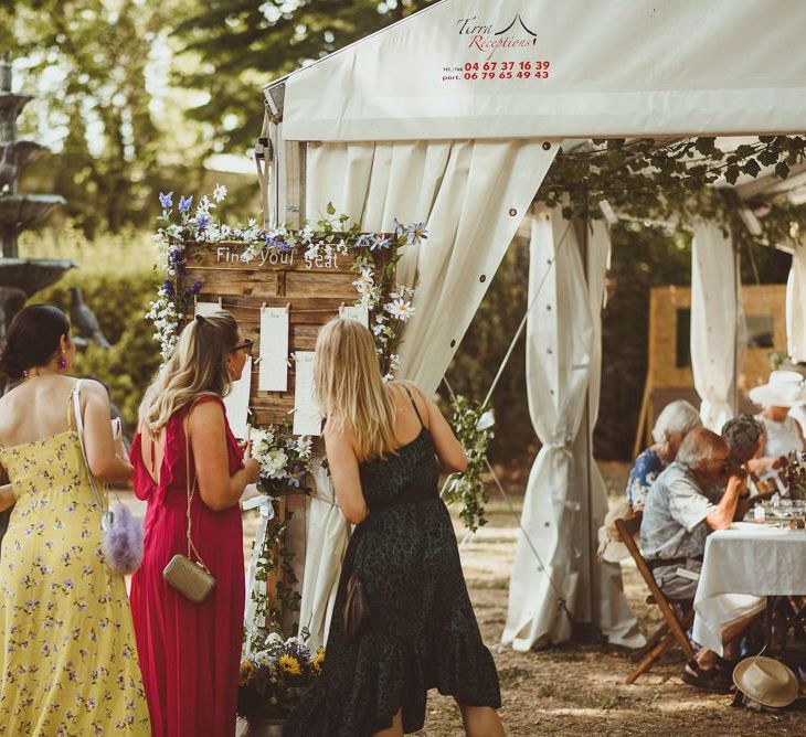 Guests Look At Table Plan at French Wedding