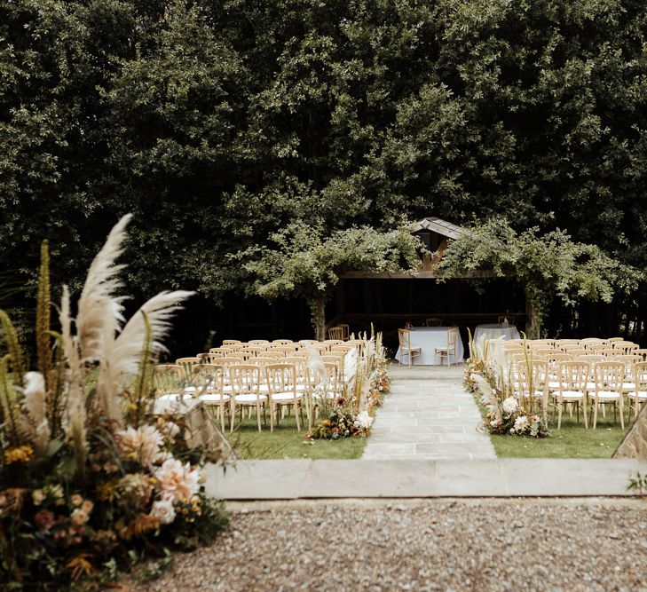 Outdoor wedding ceremony at Bury Court Barn with boho flowers