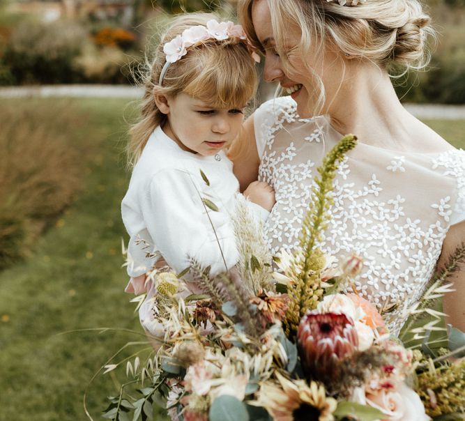 Bride in Rime Arodaky wedding dress holding her flower girl