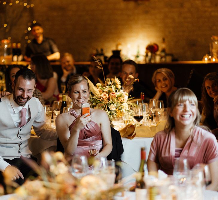 Wedding guests laughing during the wedding speeches