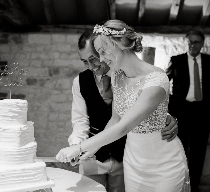 Bride and groom cutting the buttercream wedding cake