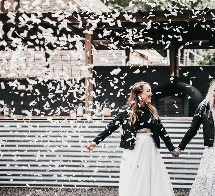 Confetti cannon moment with brides in black and white dress and separates