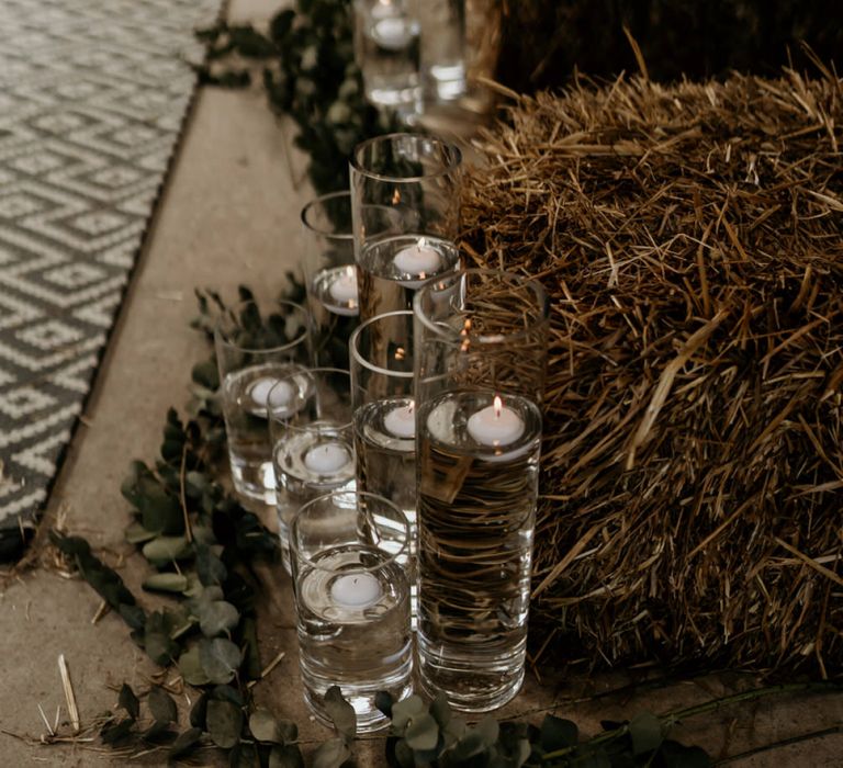 Floating Candles in Tall Vases Lining the Aisle