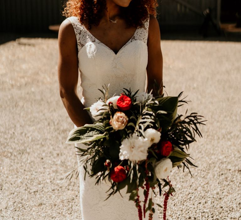 Black Bride with Afro Hair in Lace Wedding Dress Holding a Red and White Wedding Bouquet