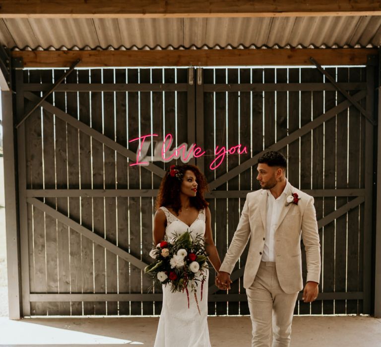 Black Bride with Afro Hair in a Lace Wedding Dress and Groom in Blazer Walking up The Aisle Lined with Rugs