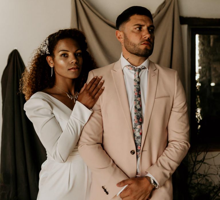 Black Bride with Afro Hair  in White Jumpsuit with Groom in Pink Blazer and Floral Tie