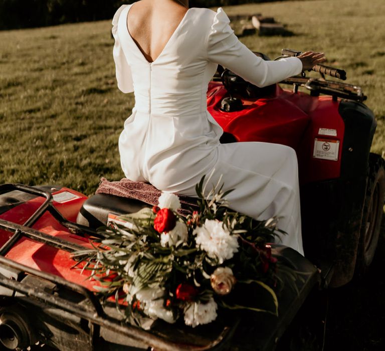 Black Bride in White Jumpsuit and Head Wrap Sitting Quad Bike