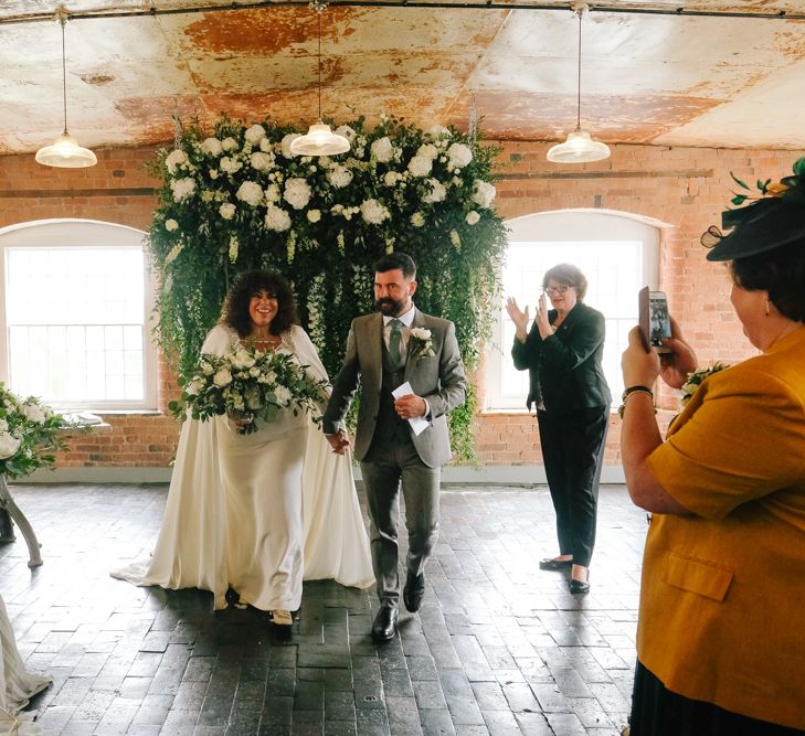 Stylish black bride in wedding cape for industrial wedding at West Derby Mill