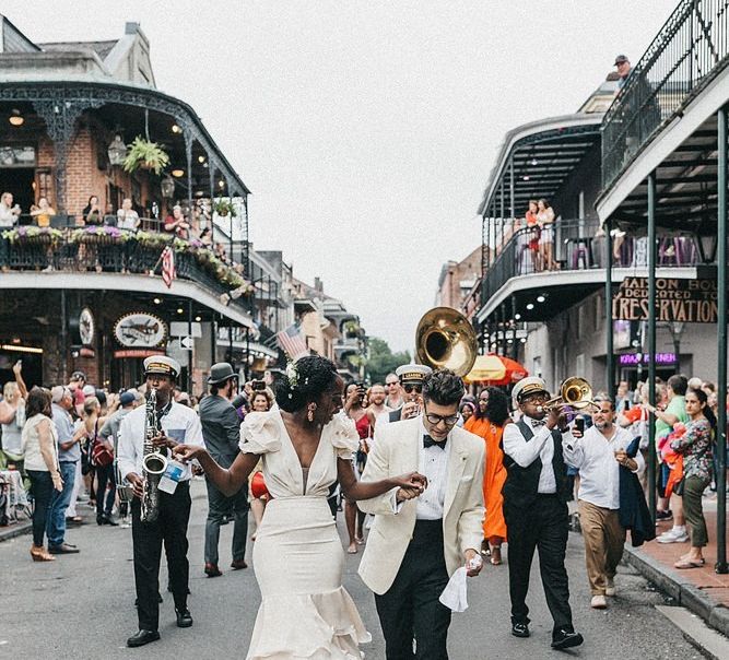 Black bride in secondhand ruffle wedding dress in street procession