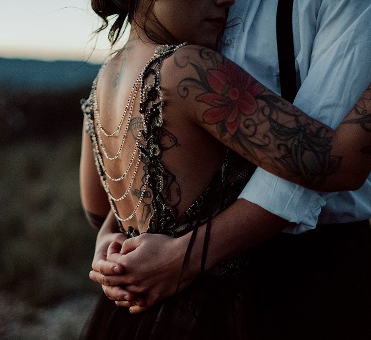 Groom Embracing Bride in Antonia Serena Atelier Wedding Dress with Black Lace and Chain Detailed Back