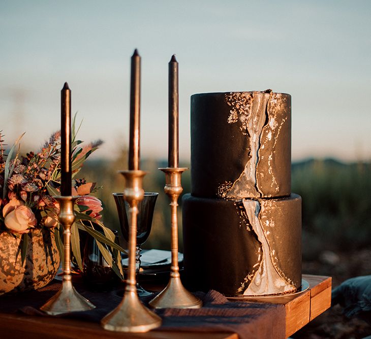 Black Wedding Cake with Front Marble Detail Next to Candlestick Decor