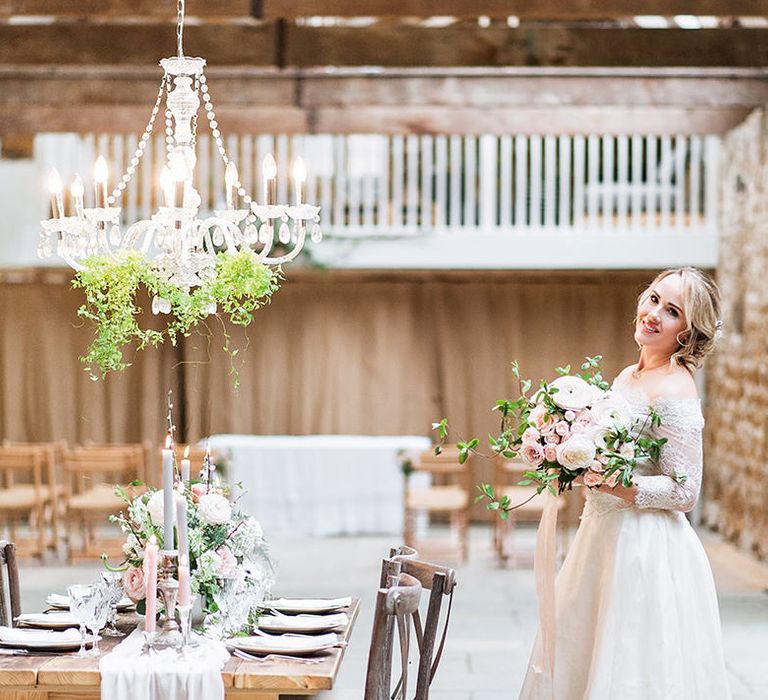 Bride in Lace, Bardot Bridal Gown | Reception Table with Hanging Chandelier | Blush Pink, Romantic, Country Wedding Inspiration at Tithe Barn, Dorset | Darima Frampton Photography