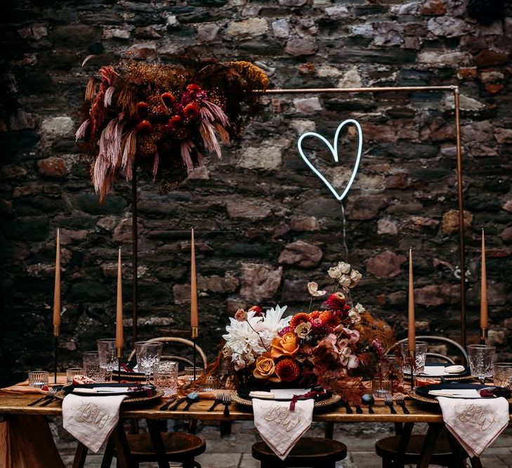 Embroidered napkins and neon sign decorating the luxury table scape