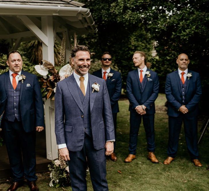 Groom in navy blue suit standing at the altar