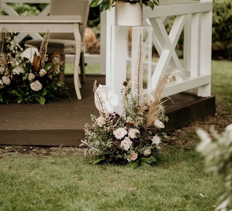 Wooden gazebo altar flowers with pampas grass, pink roses and white Anthuriums