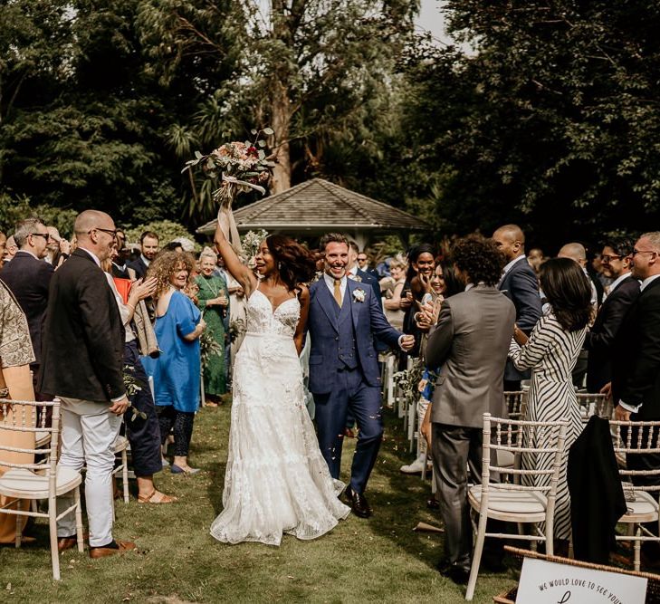 Black bride and Irish Groom walking up the aisle as husband and wife after the Nigerian wedding ceremony