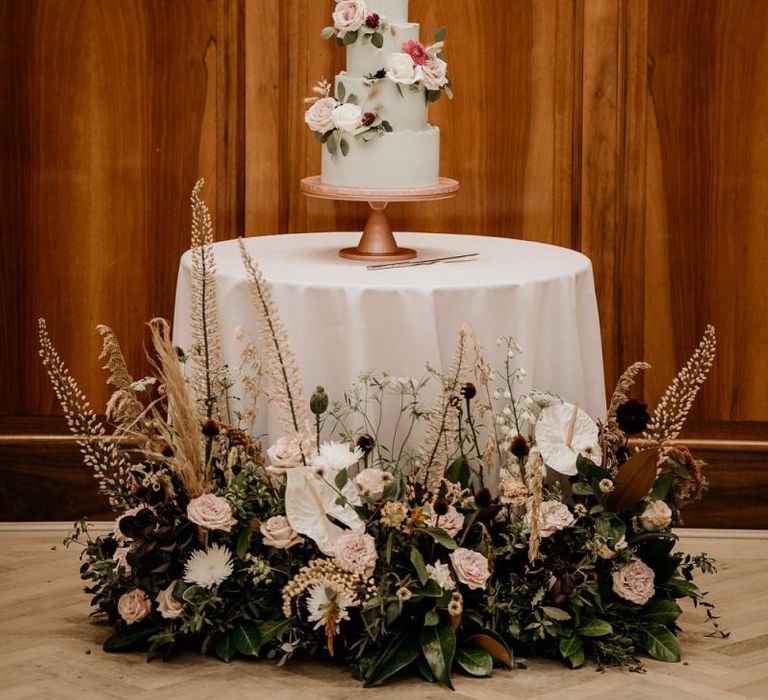 Wedding cake table decorated with floral arrangement