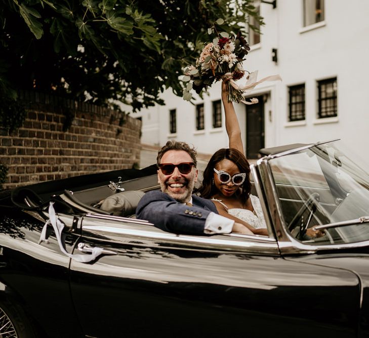 Black bride and Irish Groom in convertible wedding car