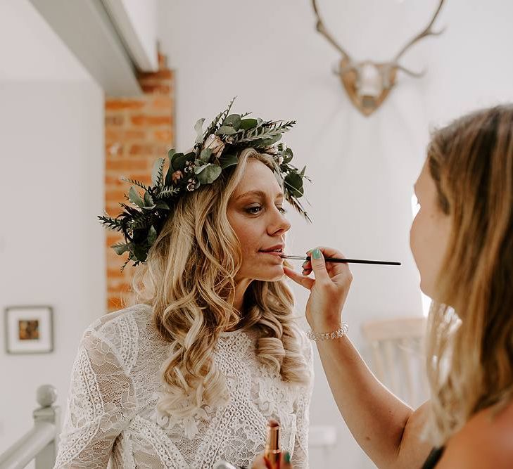 Finishing touches for bride wearing flower crown