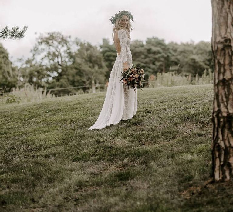 Bride in low back wedding dress with flower crown and Protea bouquet